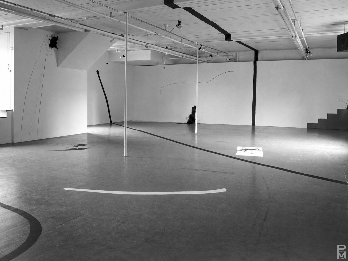 Black and white view of ART PLAY installation with painting on the gallery walls, floor and ceiling and geometric light projections across the gallery floor.