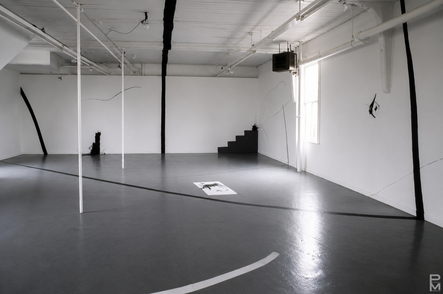 Black and white view of ART PLAY installation with painting on the gallery walls, floor and ceiling and geometric light projections across the gallery floor.