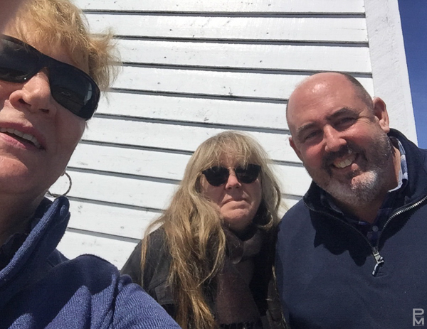 Three people smiling together in a sunny selfie