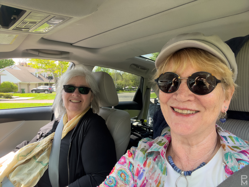 Two people smiling in a car selfie