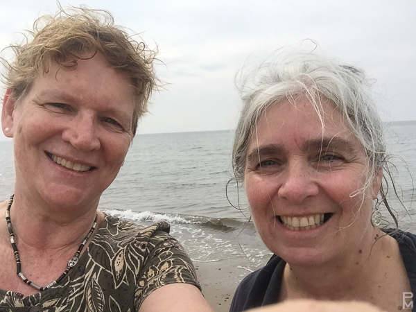 Two people smiling in a selfie on a beach