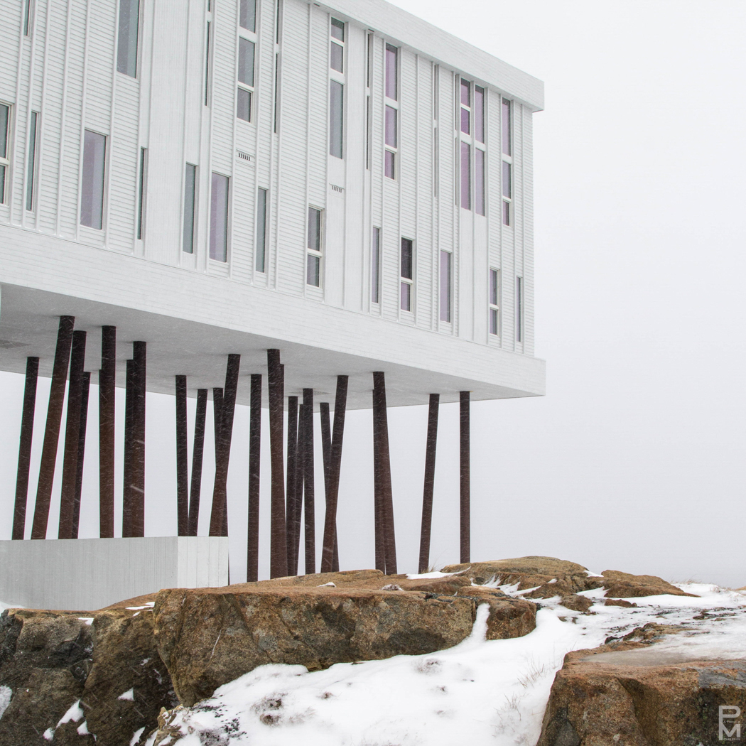 The Fogo Island Inn perched on wooden stilts above snowy rocks in Newfoundland