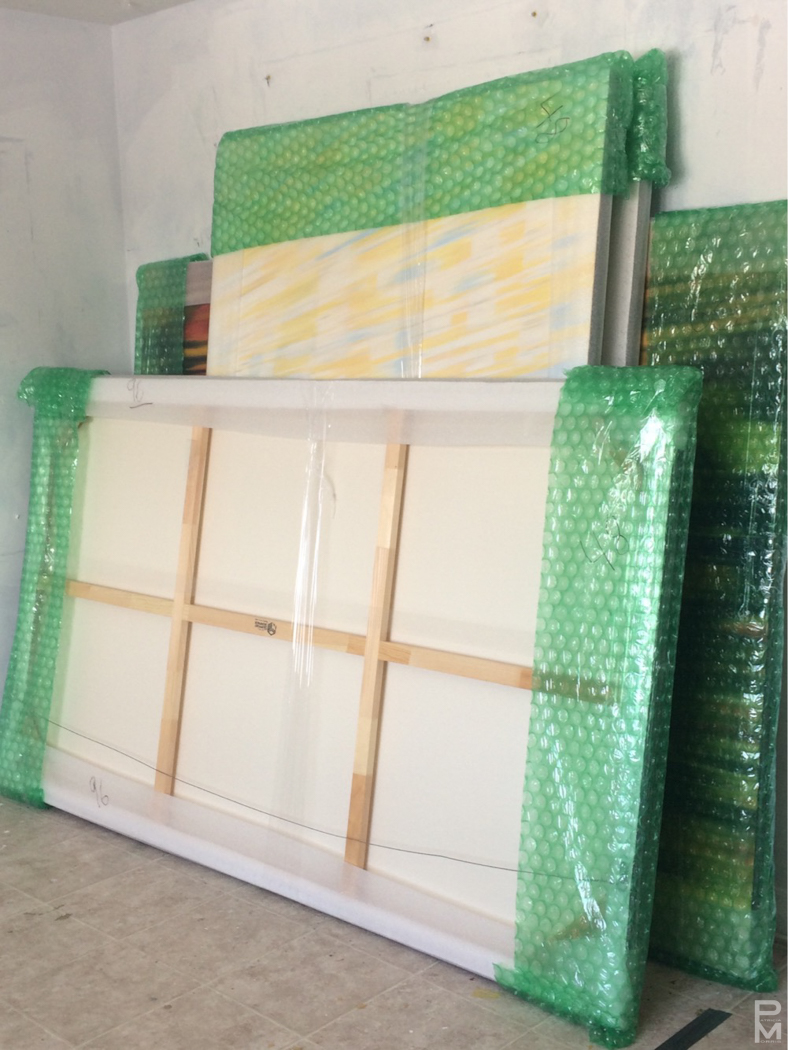 Canvases wrapped in protective bubble wrap and packing paper, ready to be shipped