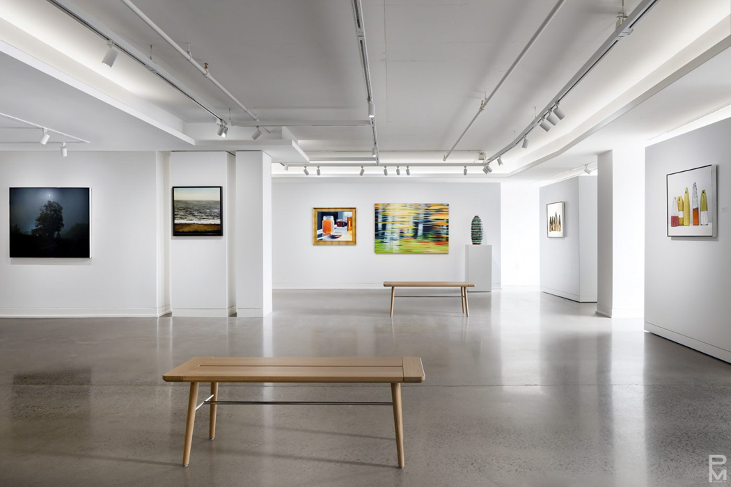 Paintings installed on white walls in a gallery exhibition space