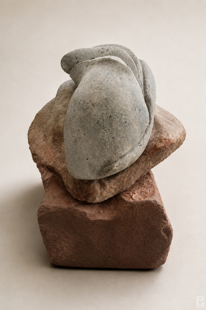 stone sculpture with three stacked pieces, 2 red sandstone pieces create the base
    which supports a white limestone piece resembling a bud.