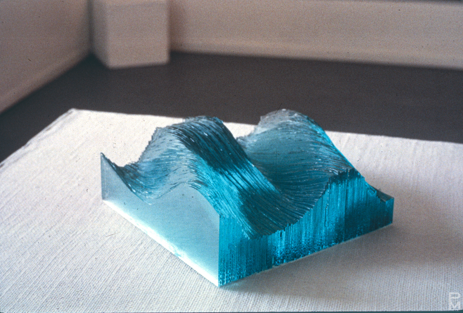 Sculpture made of stacked pieces of glass, resembling a wave.